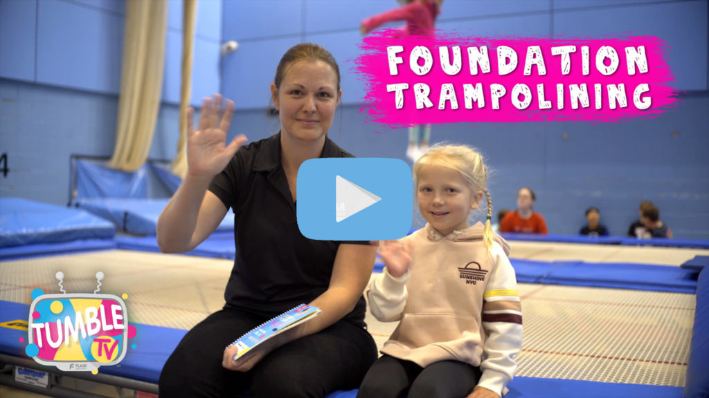 Coach sits next to foundation level trampolinist at Flair Gymnastics