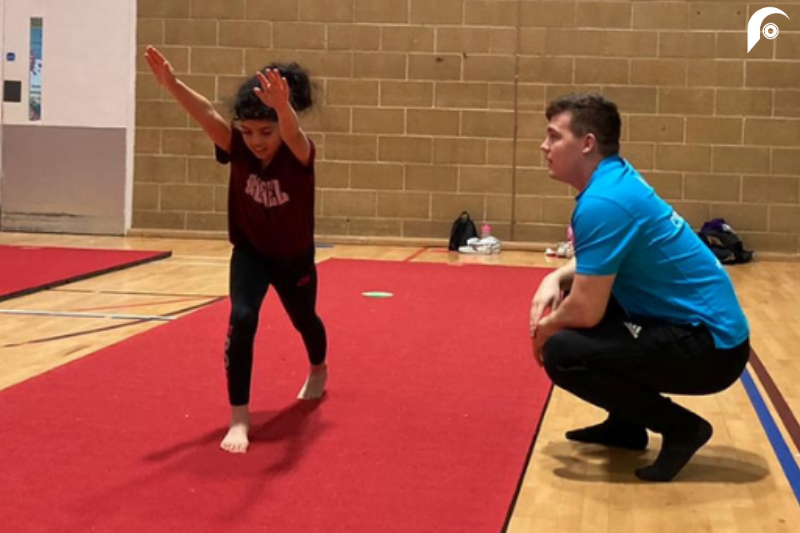Alex coaching a child gymnastics at Guildford Spectrum