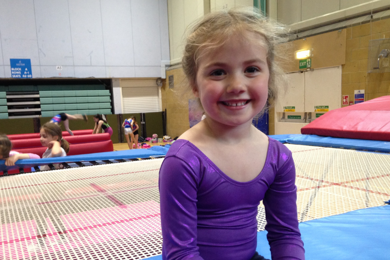 Emmy loves Trampolining - young girl sitting on trampoline
