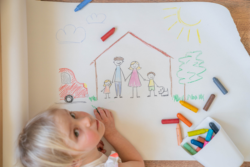 A child drawing a family in a house.